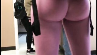 Una candida telecamera bionda rivela il suo corpo sexy con indosso leggings rosa attillati